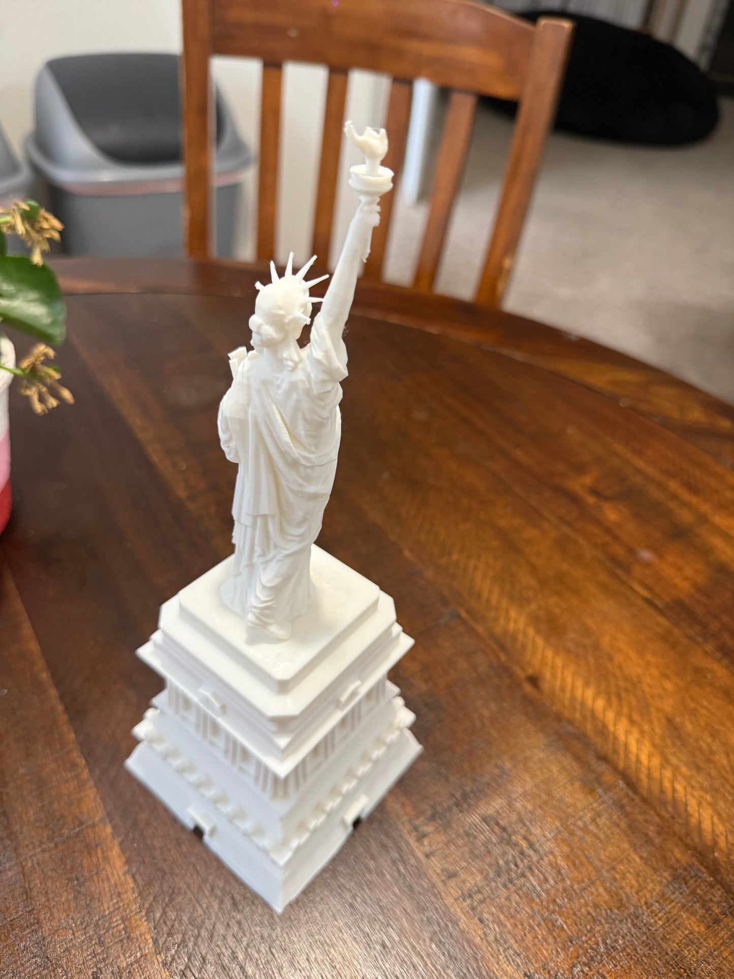 Overhead angled view of the 3D printed Statue of Liberty model emphasizing the back side and raised torch.