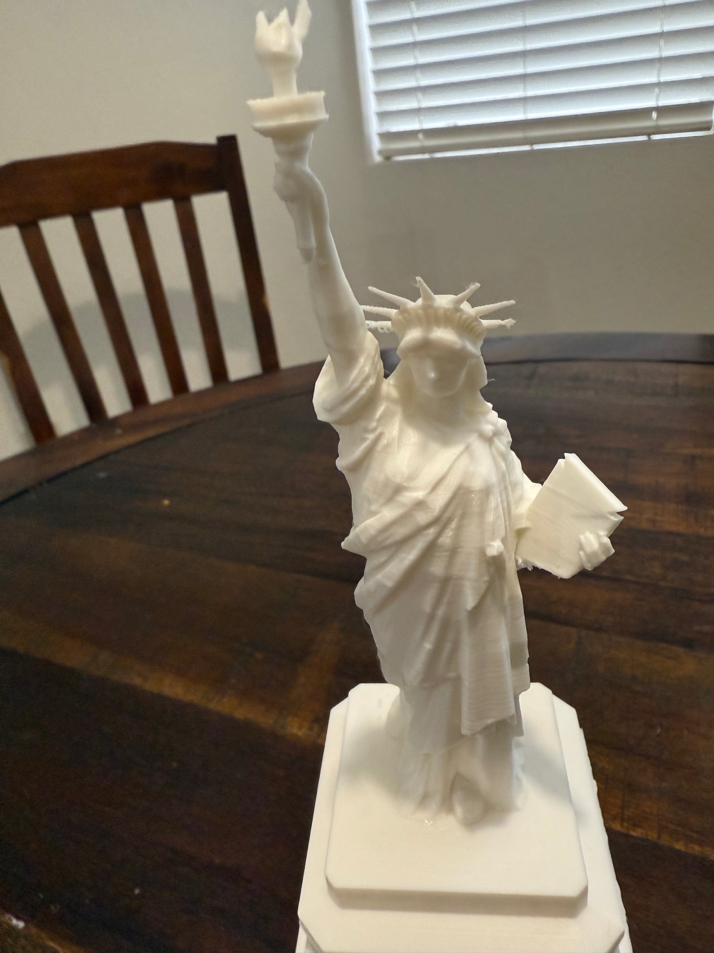 Zoomed-in shot of the upper body of the 3D printed Statue of Liberty showing facial detail and arm positioning.